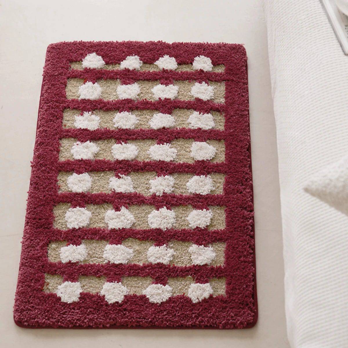 Geometric bath mat with red border and white dot pattern.