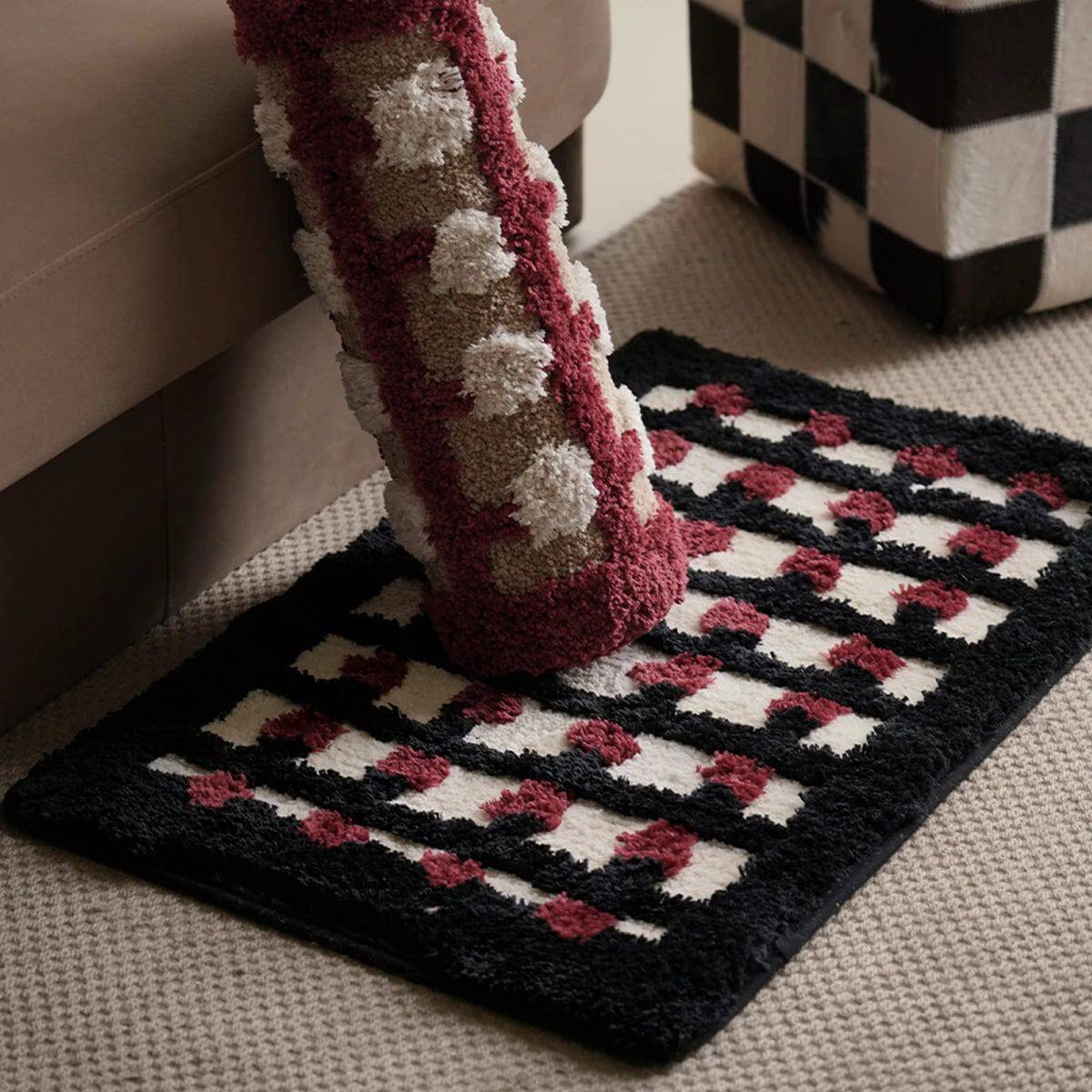 Geometric bath mat with black, white, and red pattern, cozy footstep design.