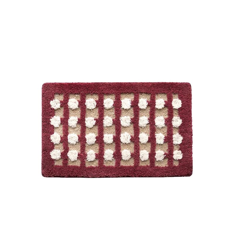 Geometric bath mat with red border and white pom-pom pattern.