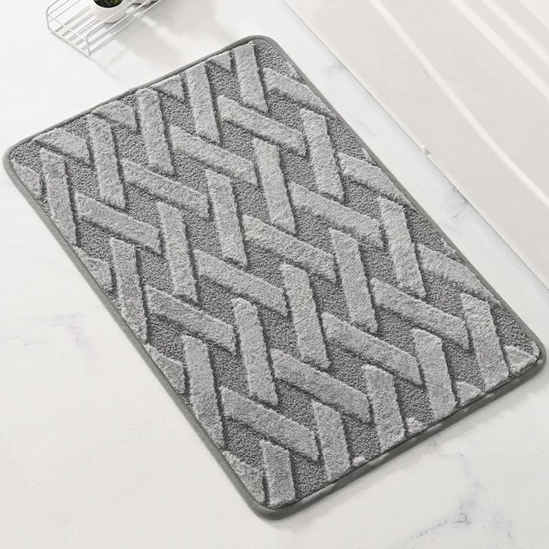 Gray geometric pattern bath mat with textured herringbone design.