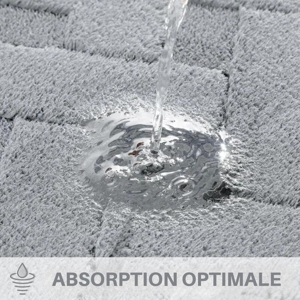 Gray geometric bath mat absorbing water quickly for optimal absorption.