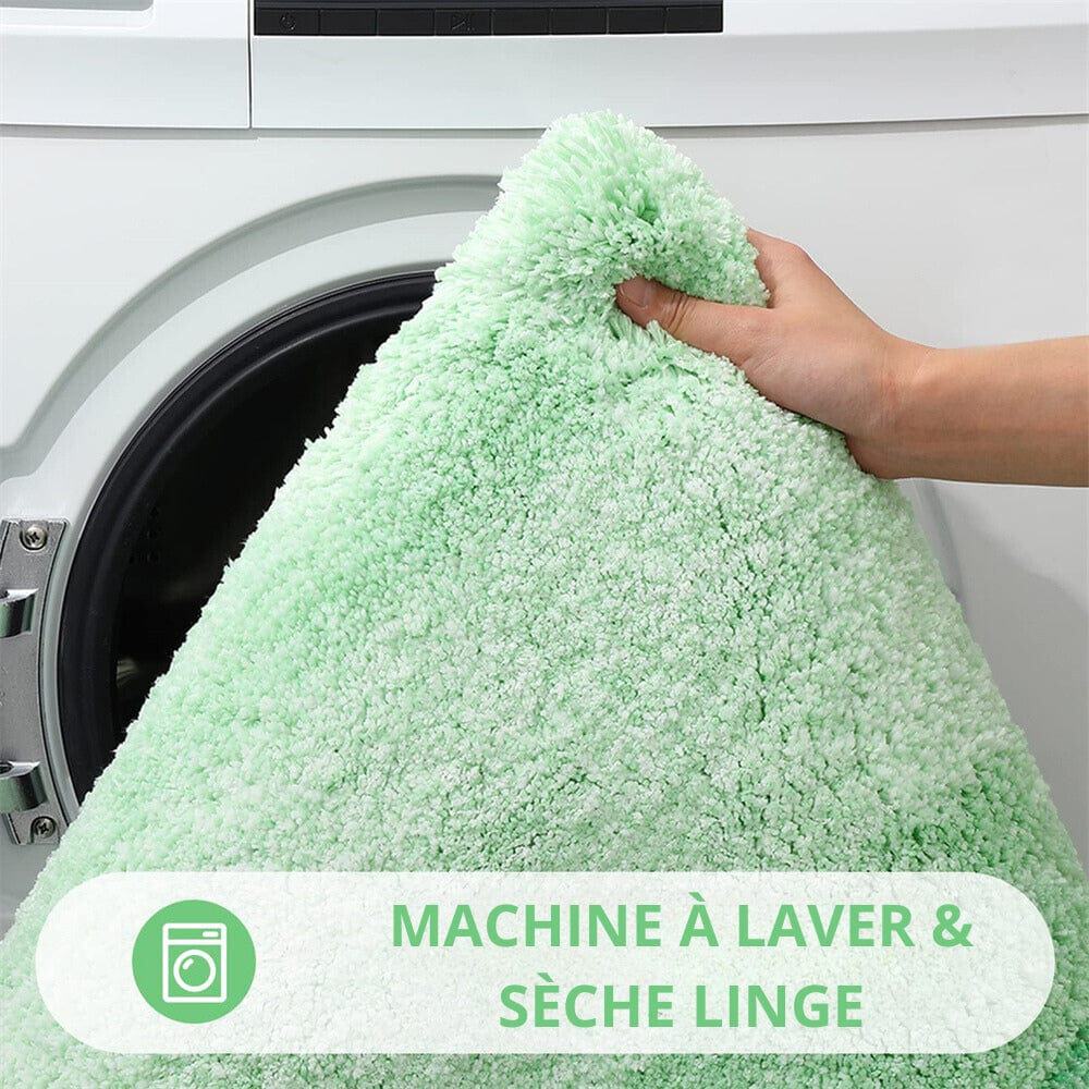 Green white fluffy bath mat being held near washing machine.