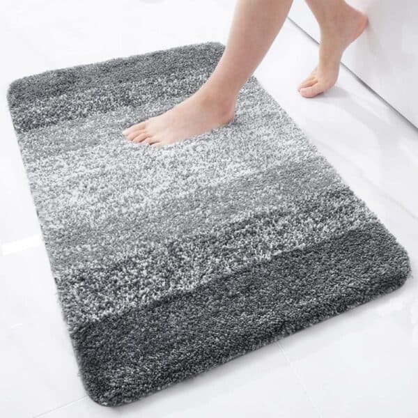 Grey and white gradient plush bath mat for bathroom comfort.