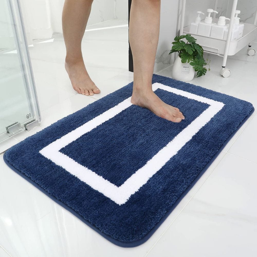 Large absorbent bath mat with white border for bathroom.