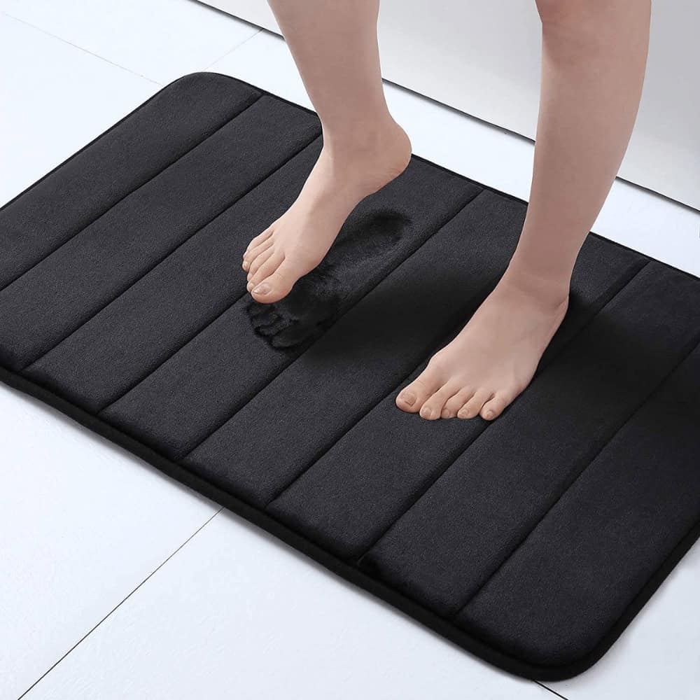 Large fluffy black bath mat with cushioned stripes for comfort and style.