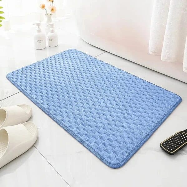 Light blue textured bath mat for bathroom comfort and style.