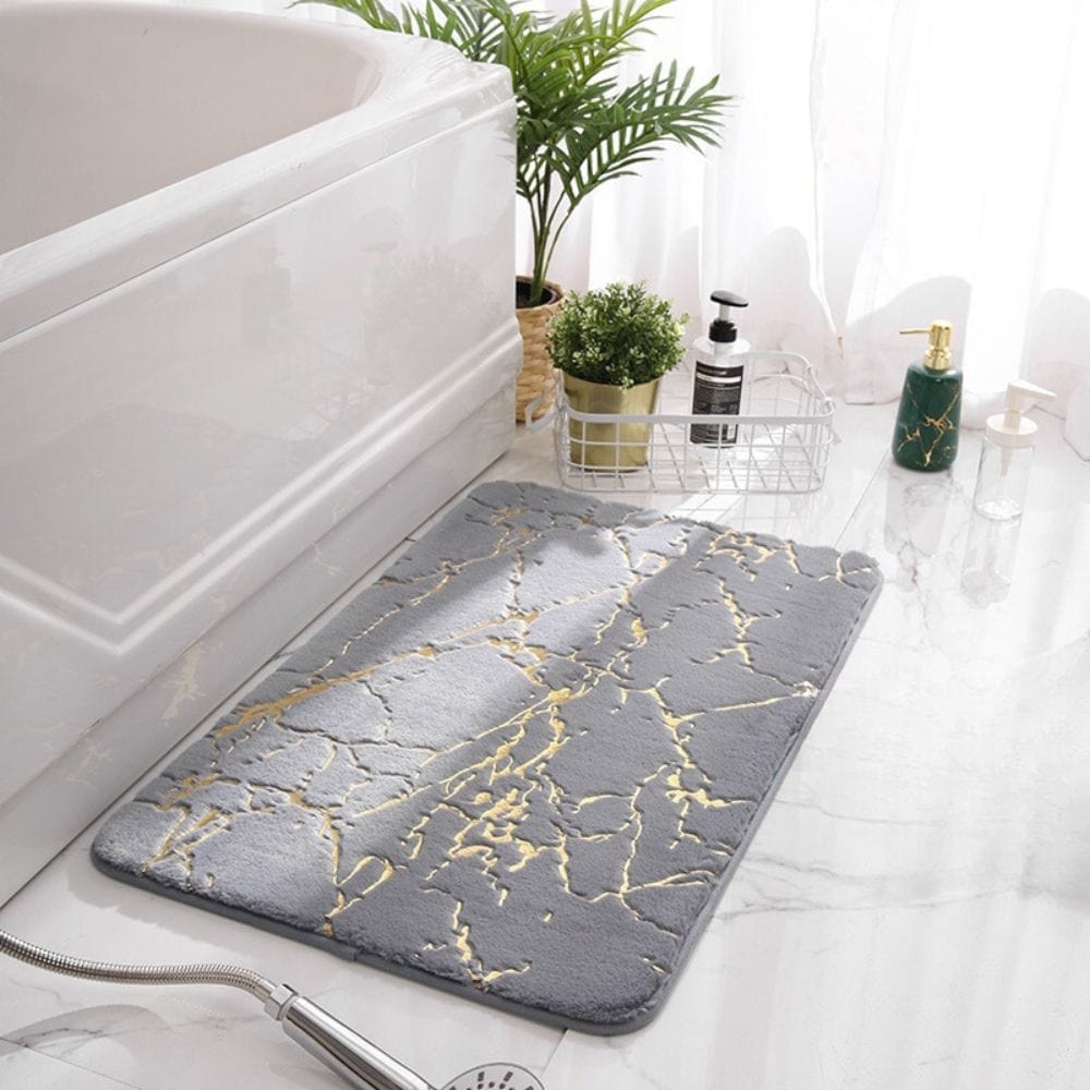 Grey marble effect bath mat with gold veins for modern bathroom decor.