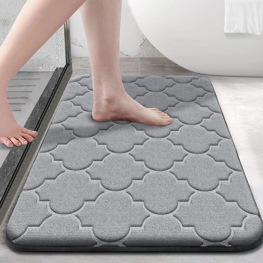 Gray memory foam bath mat with patterned design for comfort and safety.