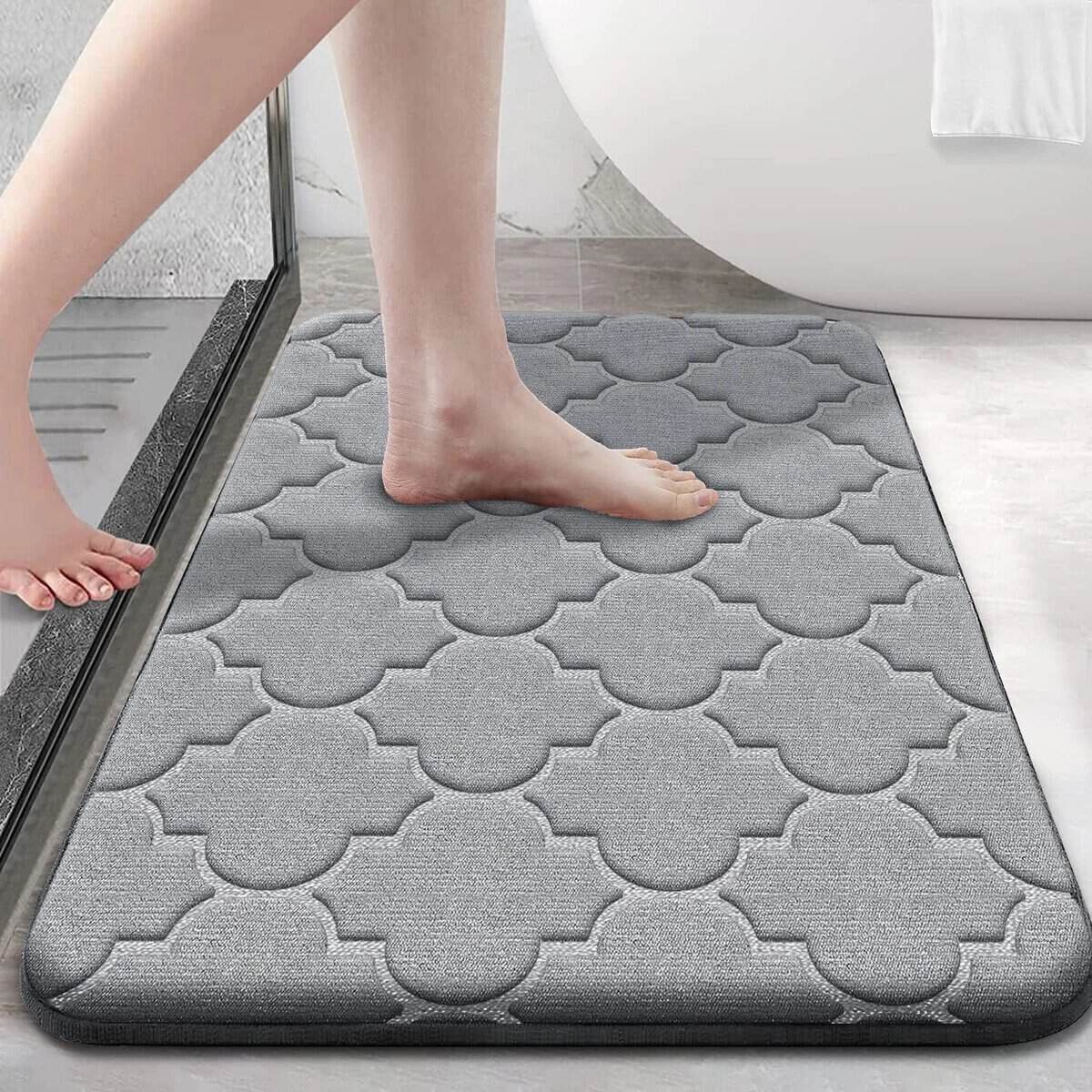 Gray memory foam bath mat with patterned design for comfort and safety.