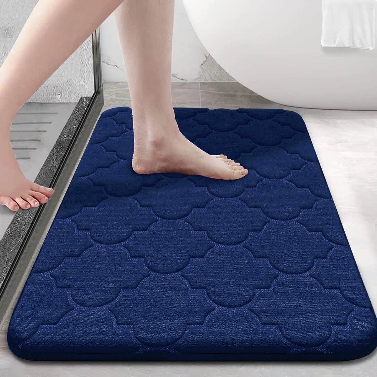Blue memory foam bath mat with quilted pattern for comfort and grip.