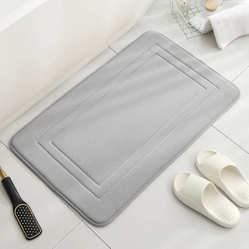 Gray memory foam bath mat with stitched border for bathroom comfort.