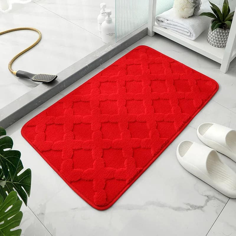 Red microfibre bath mat with quilted pattern for bathroom comfort.