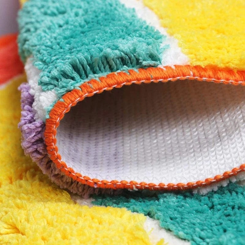 Multicoloured bath mat with fringed edges and textured weave.