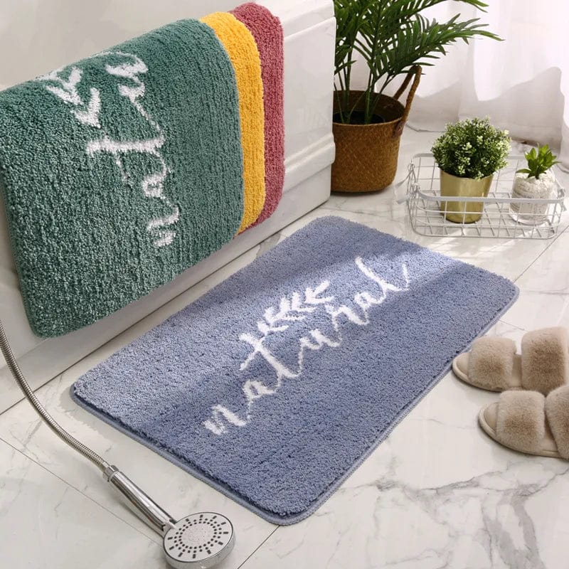 Blue natural bath mat with white script, cozy bathroom decor.