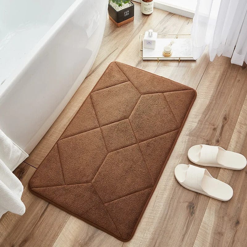 Brown non-slip bath mat with geometric stitching on wooden floor.