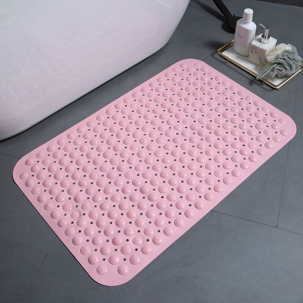 Pink non-slip bath mat with textured dots for safety in bathroom.