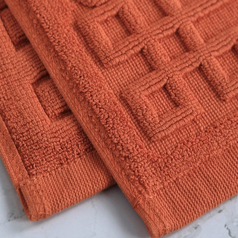 Non slip cotton bath mat in terracotta orange with textured pattern.