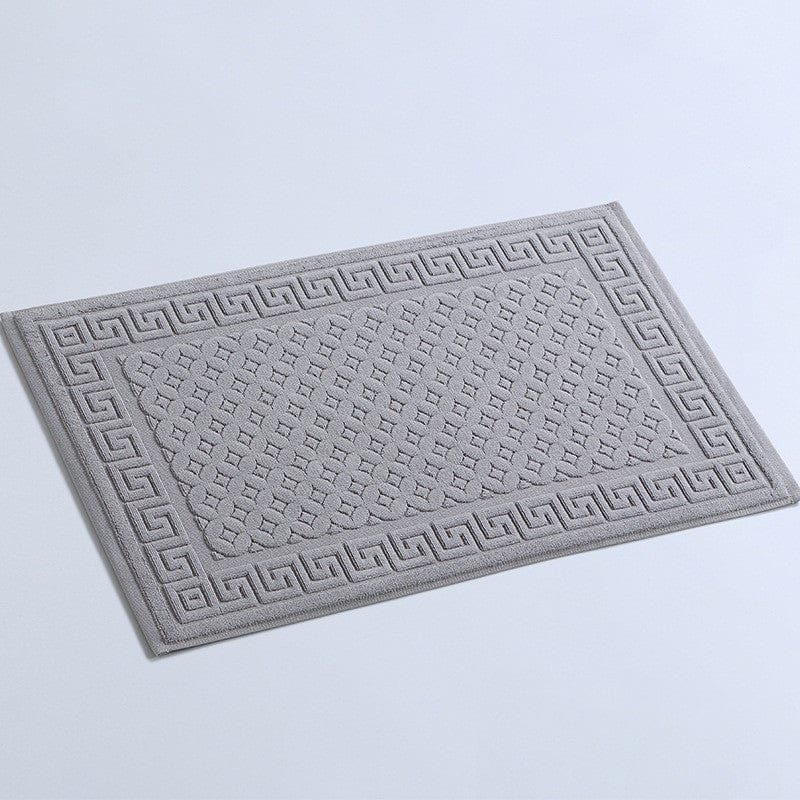 Non slip cotton bath mat with Greek key pattern for bathroom safety.