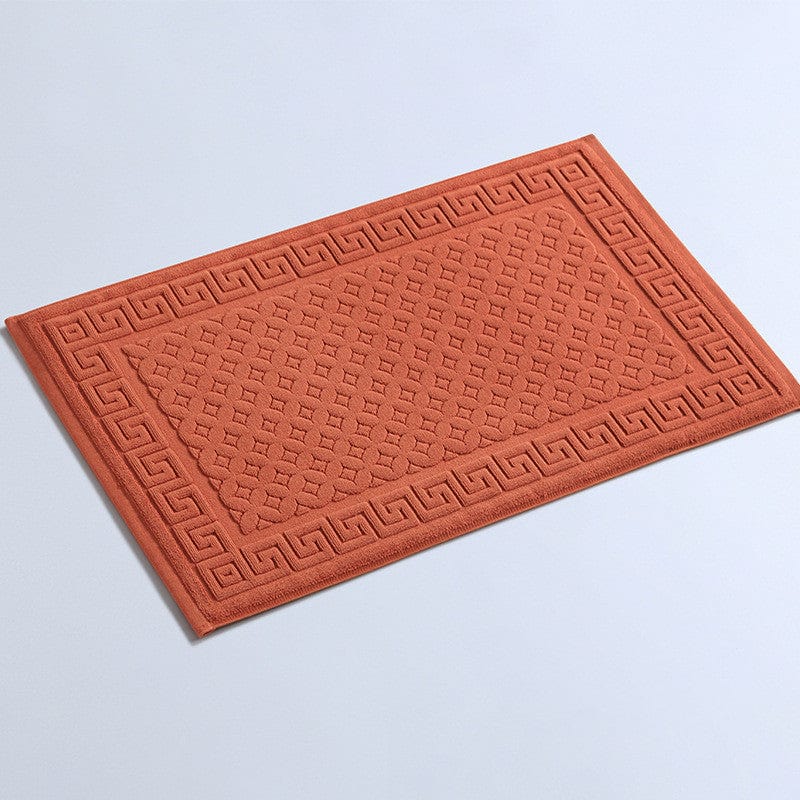 Non slip cotton bath mat with Greek key pattern in terracotta.