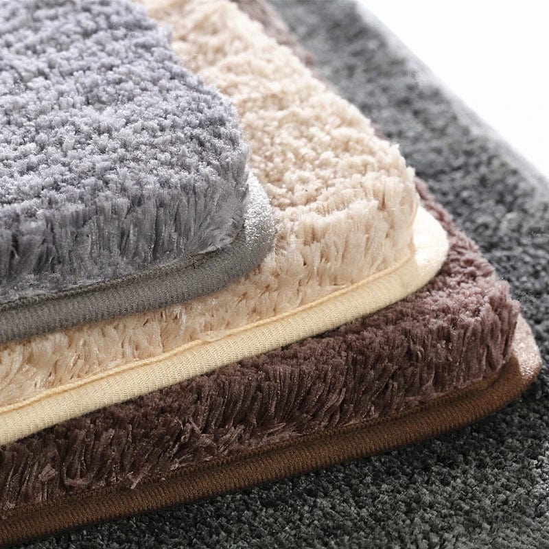 Non-slip bath mat with plush texture in grey, beige and brown.