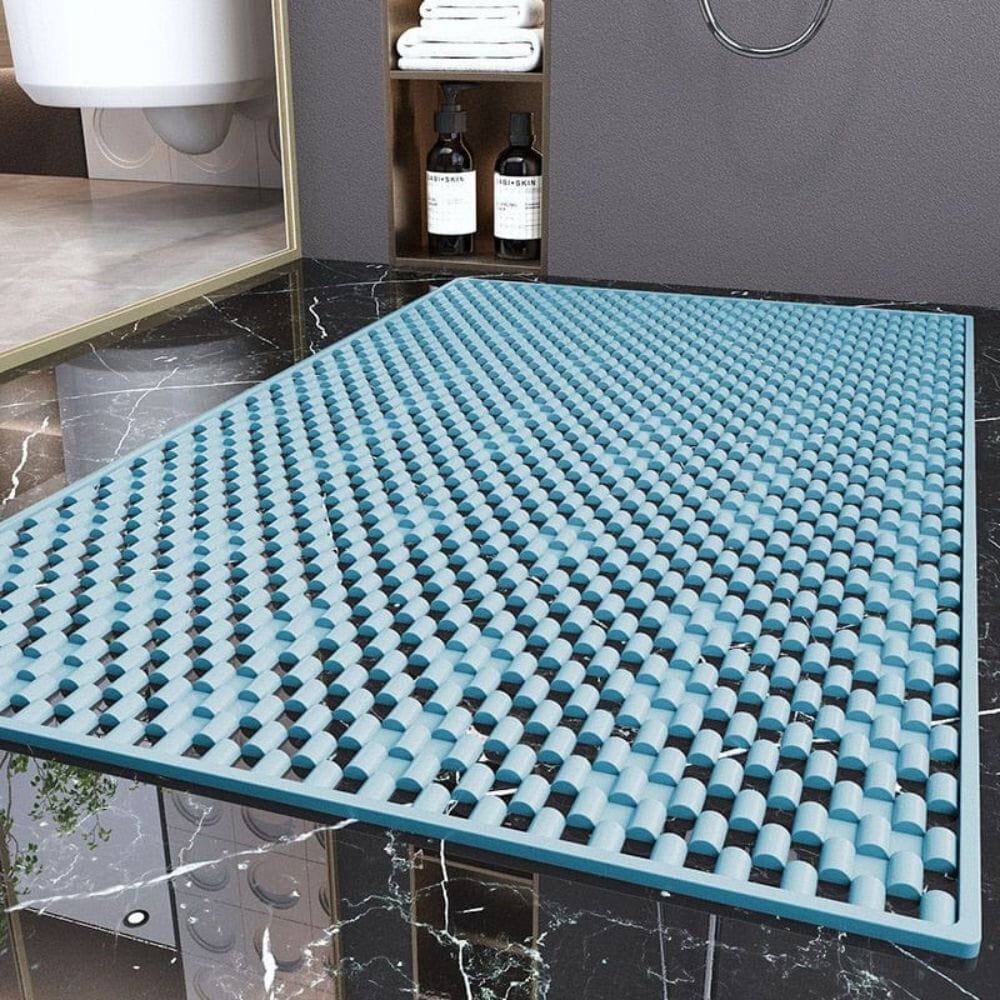 Blue non-slip shower bath mat with textured grip for safety in wet bathroom.