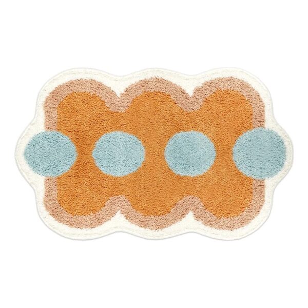 Orange bath mat with blue circles and scalloped edge.