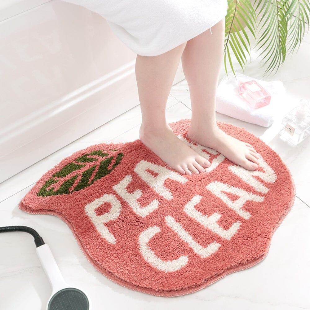 Peach-shaped bath mat with 'PEACH CLEAN' text, cozy bathroom decor.