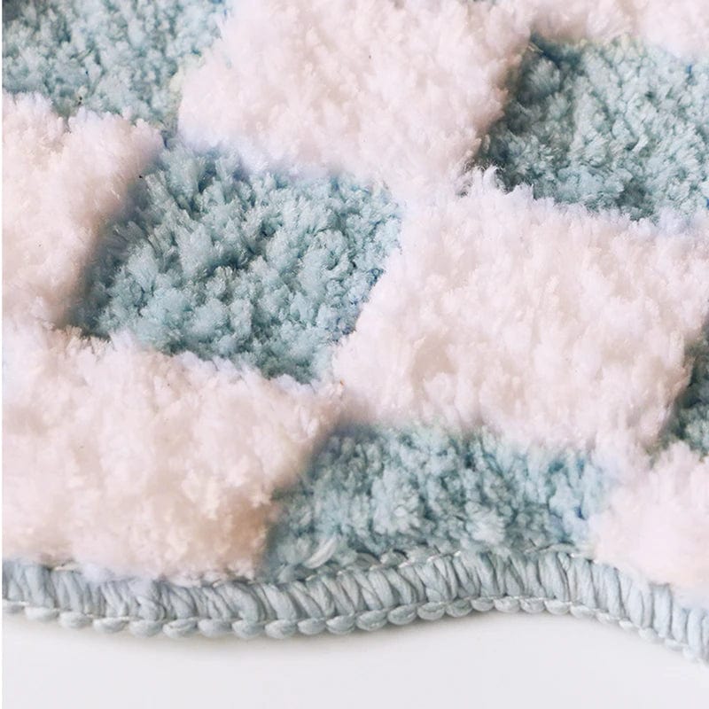 Soft peachy bath mat with pastel blue and white fluffy texture.