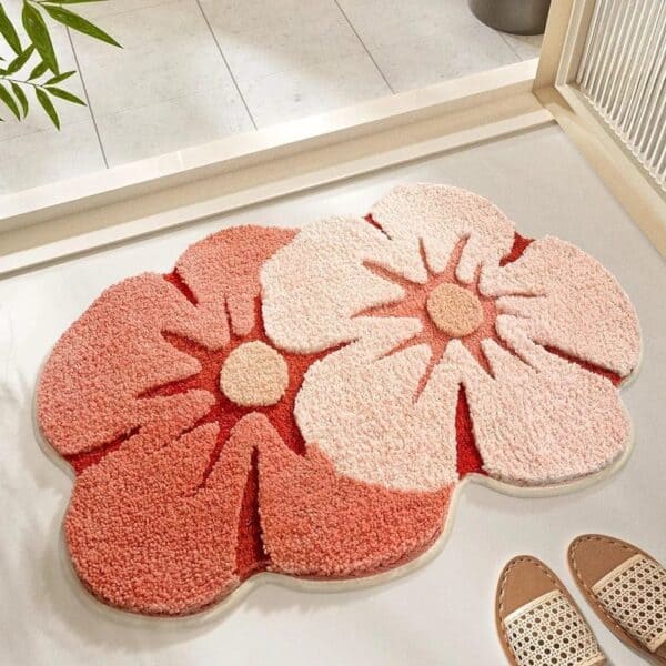 Pretty floral bath mat with soft pink and coral petals for bathroom decor.