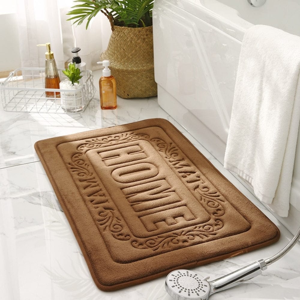Rectangular brown bath mat with 'HOME' embossed design for cozy bathroom decor.