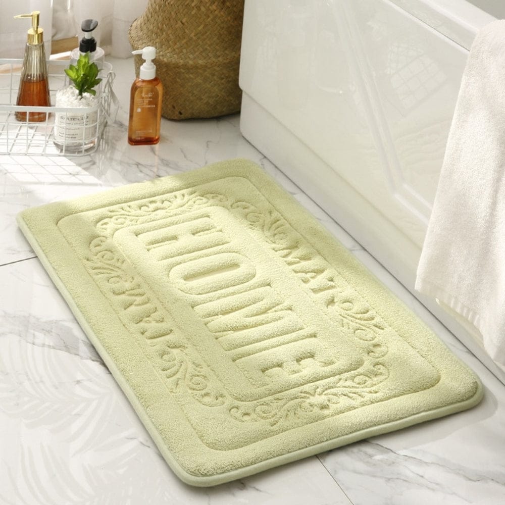 Rectangular bath mat with 'HOME' embroidery, soft green, bathroom decor.