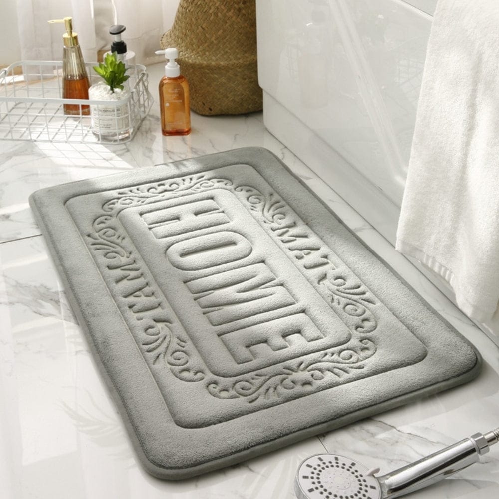 Gray rectangular bath mat with 'HOME' embossed design for bathroom.