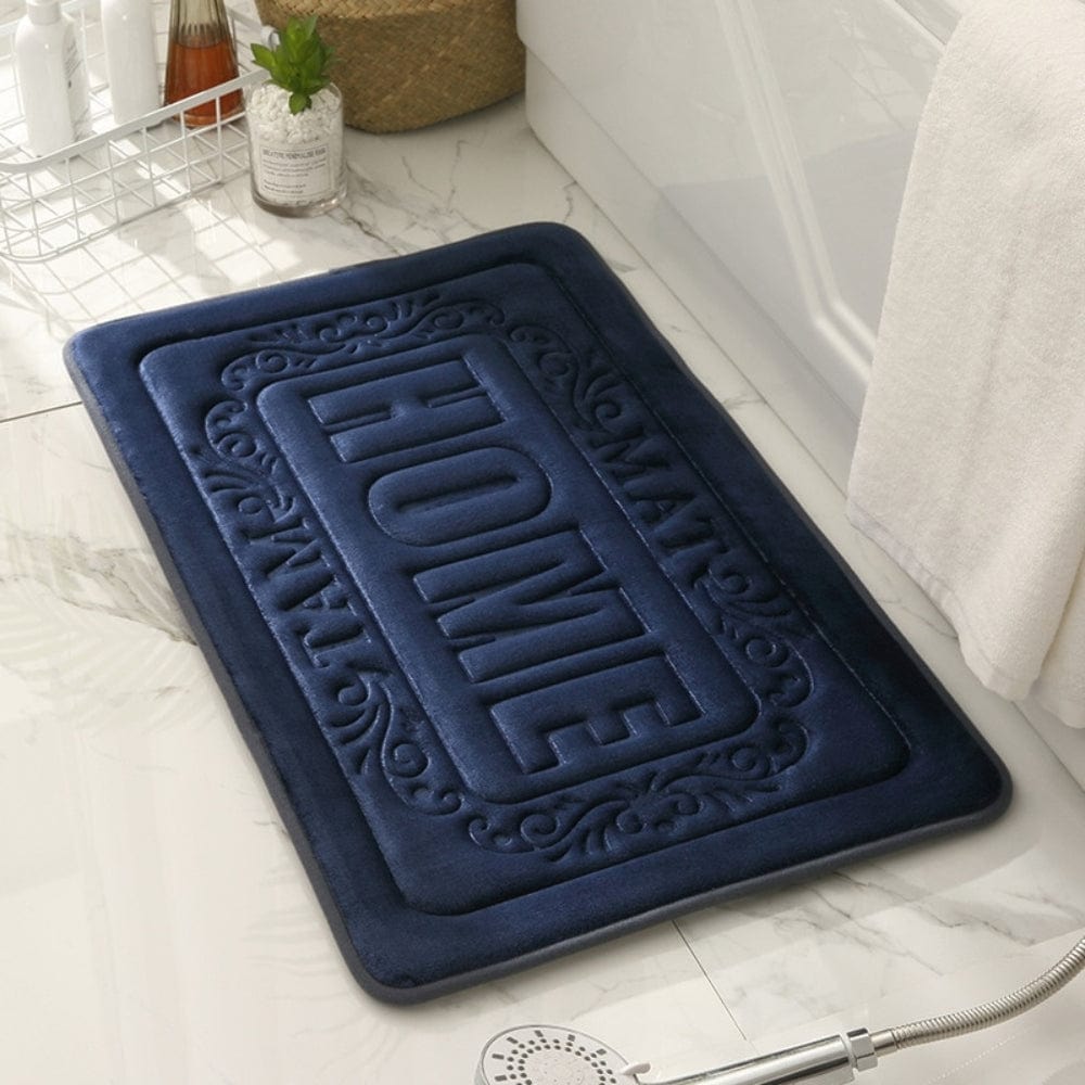 Blue rectangular bath mat with 'HOME' embossed design for bathroom.