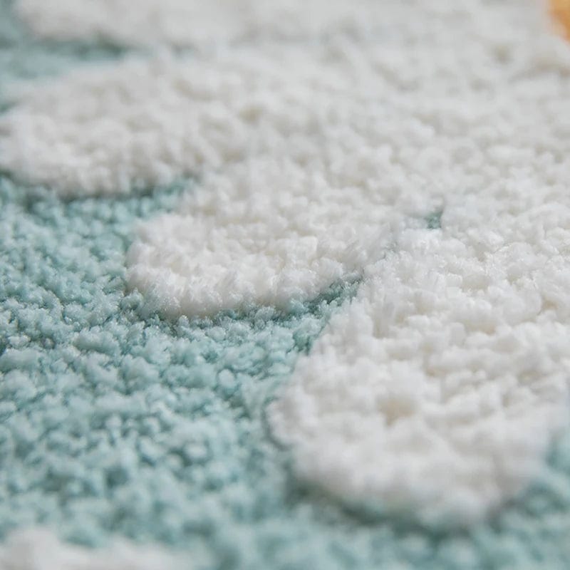 Scandi style bath mat with fluffy white cloud design on mint green background.