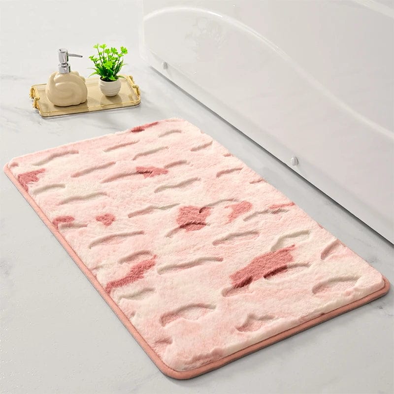 Pink shaggy bath mat with floral pattern beside bathtub.