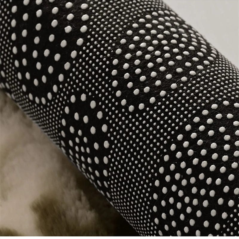 Black shaggy bath mat with white dot texture for non-slip grip.