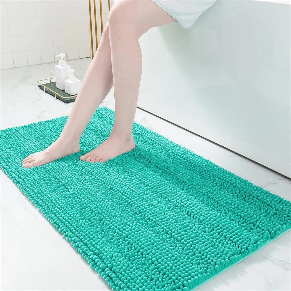 Small teal fluffy bath mat with feet stepping on it.