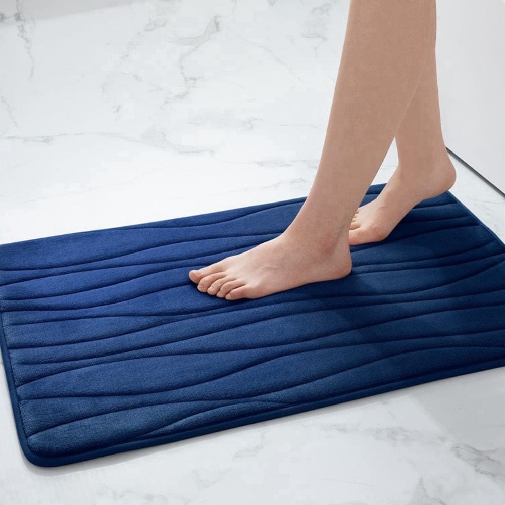 Blue textured bath mat for small bathroom, comfortable non-slip footing.