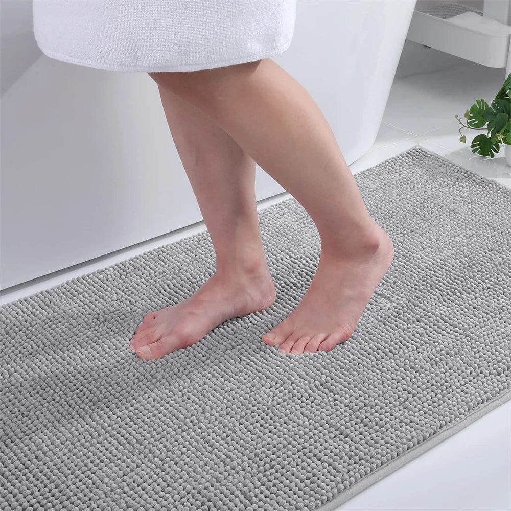 Small thin grey bath mat with textured surface for bathroom comfort.