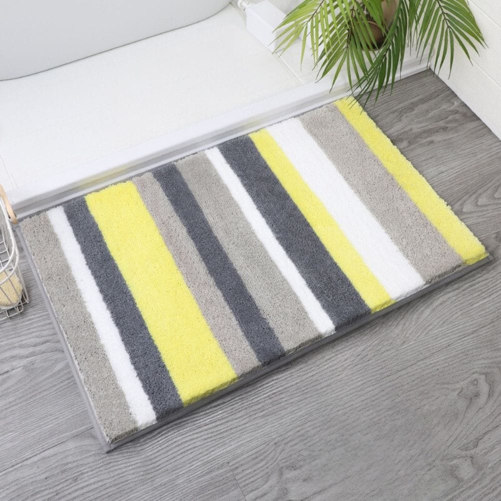Yellow, grey, and white striped bath mat for modern bathroom decor.