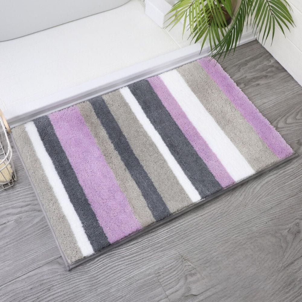 Purple, grey, and white striped bath mat for bathroom.