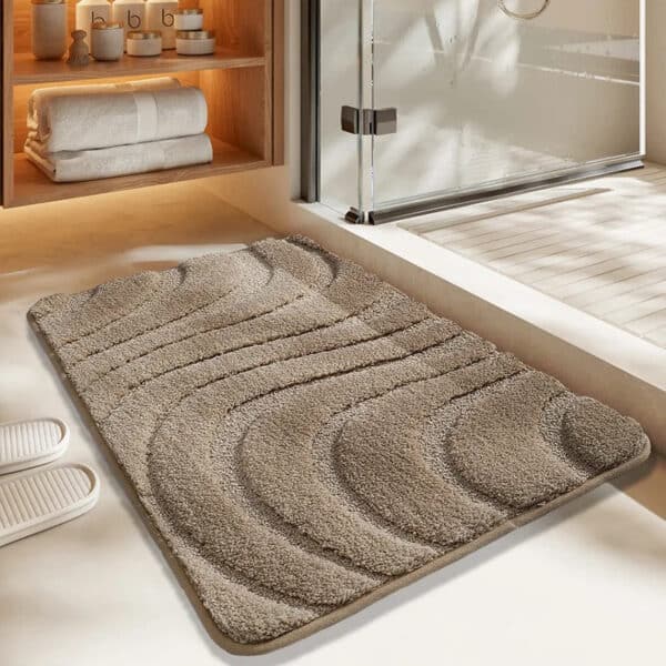 Tan textured bath mat with wave pattern for modern bathroom.