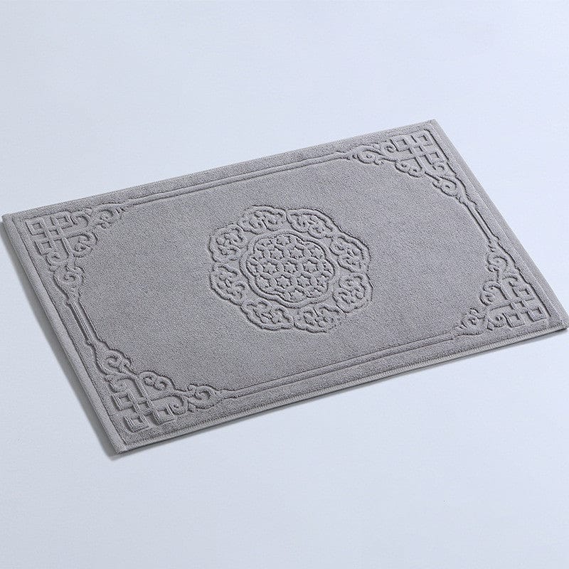 Thick cotton bath mat with intricate grey floral and geometric embroidery design.