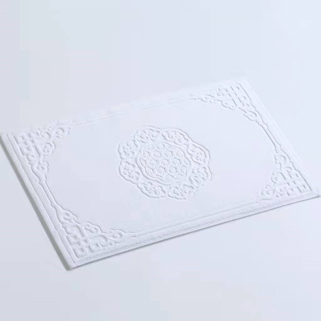 Thick cotton bath mat with intricate embroidered pattern.