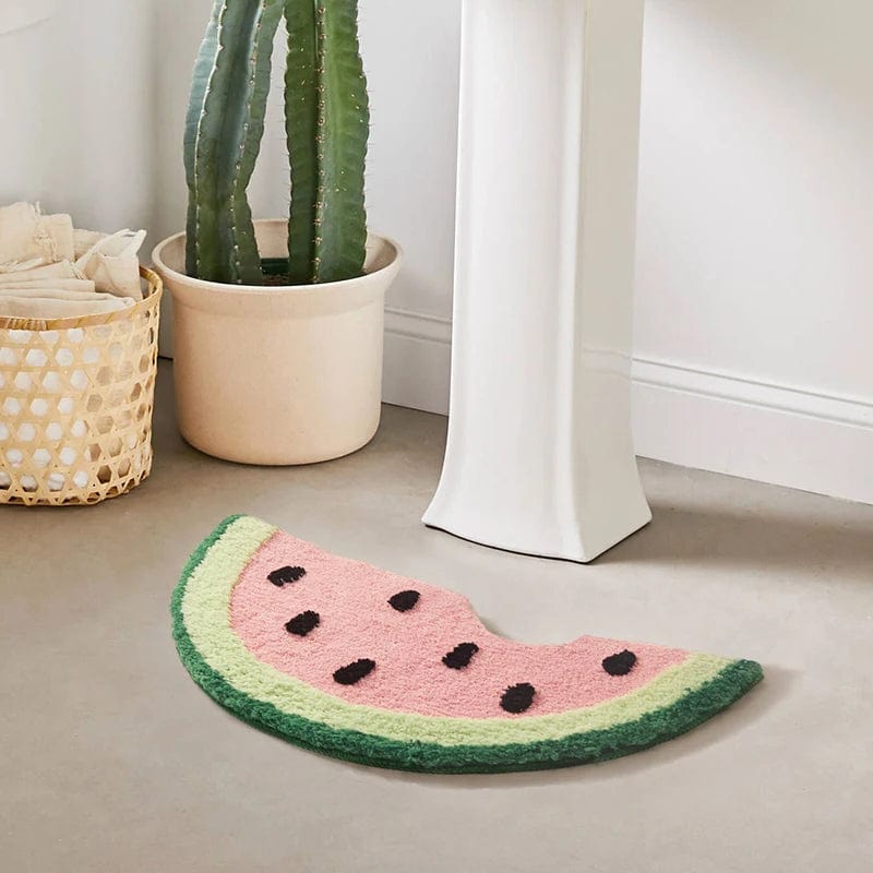 Watermelon slice bath mat with black seeds and green rind.