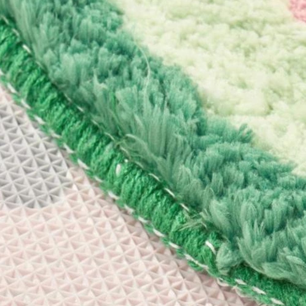 Watermelon-themed bath mat with green fringed edge and textured non-slip backing.