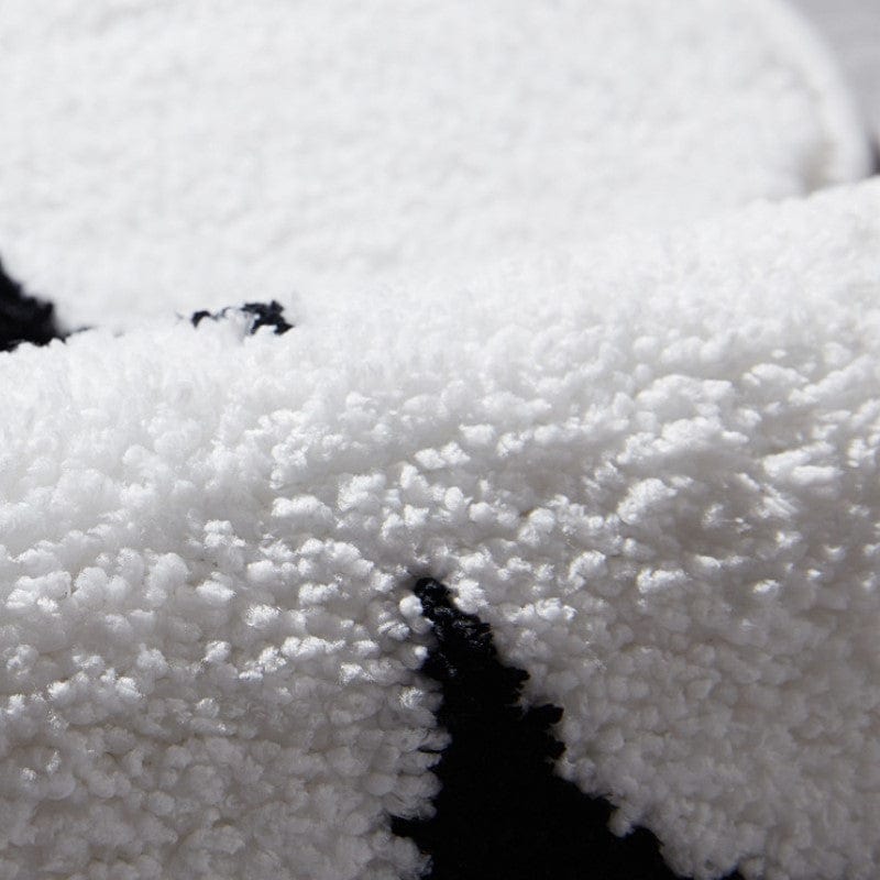 White and black plush bath mat close-up texture.